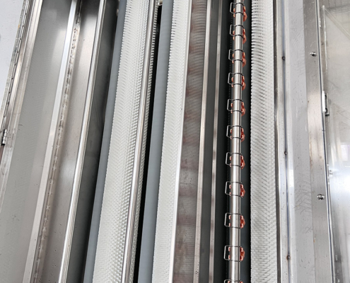 Washing brushes and stainless steel spray bar inside the Techwin vertical glass washing machine